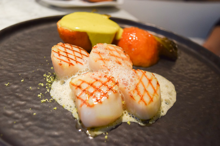 Les noix de Saint-Jacques grillées, pistache, olive verte, céleri de chez Joël Thiebault à la broche