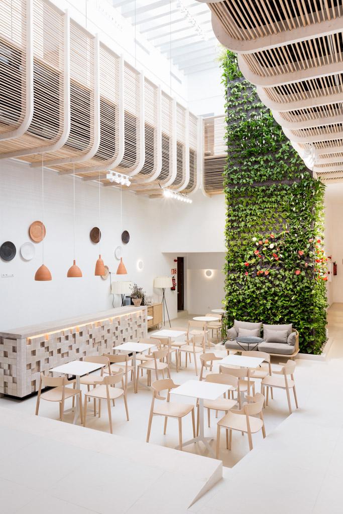 À l’intérieur, un vaste patio abrite du mobilier design ainsi qu’un mur végétal