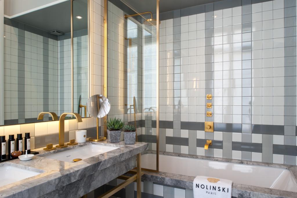 Dans les salles de bain, marbre et laiton sont à l’honneur