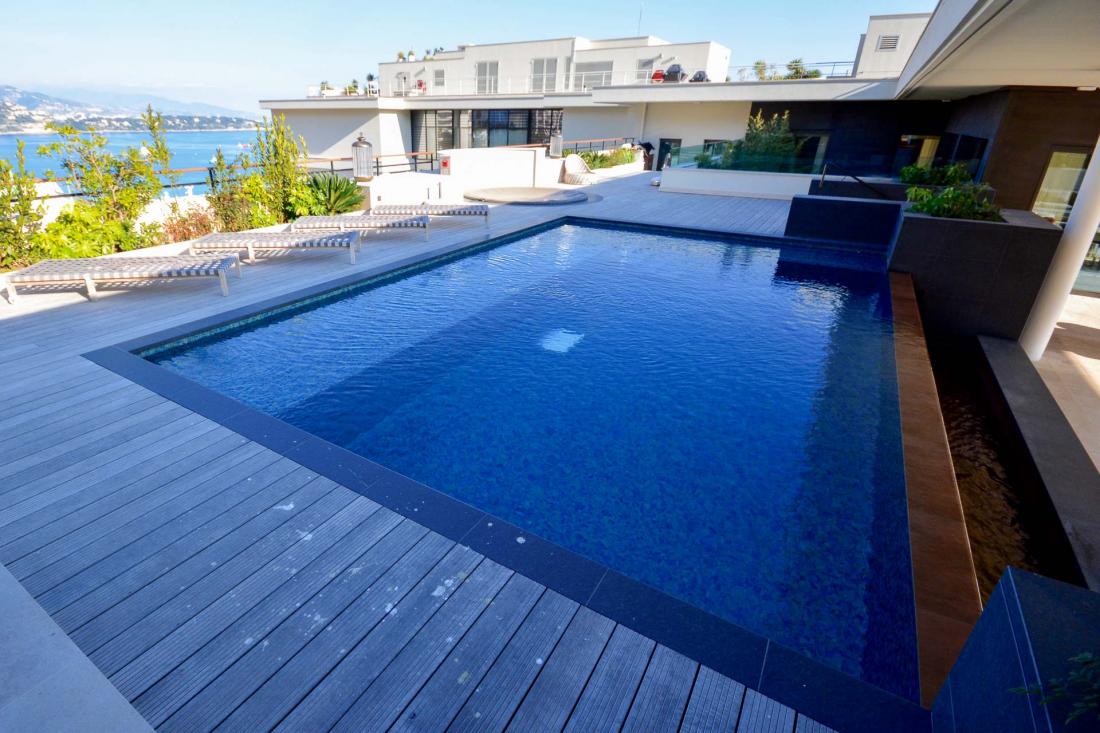 ...une piscine chauffée à débordement ouverte sur un salon extérieur attenant et un jacuzzi en granit rare