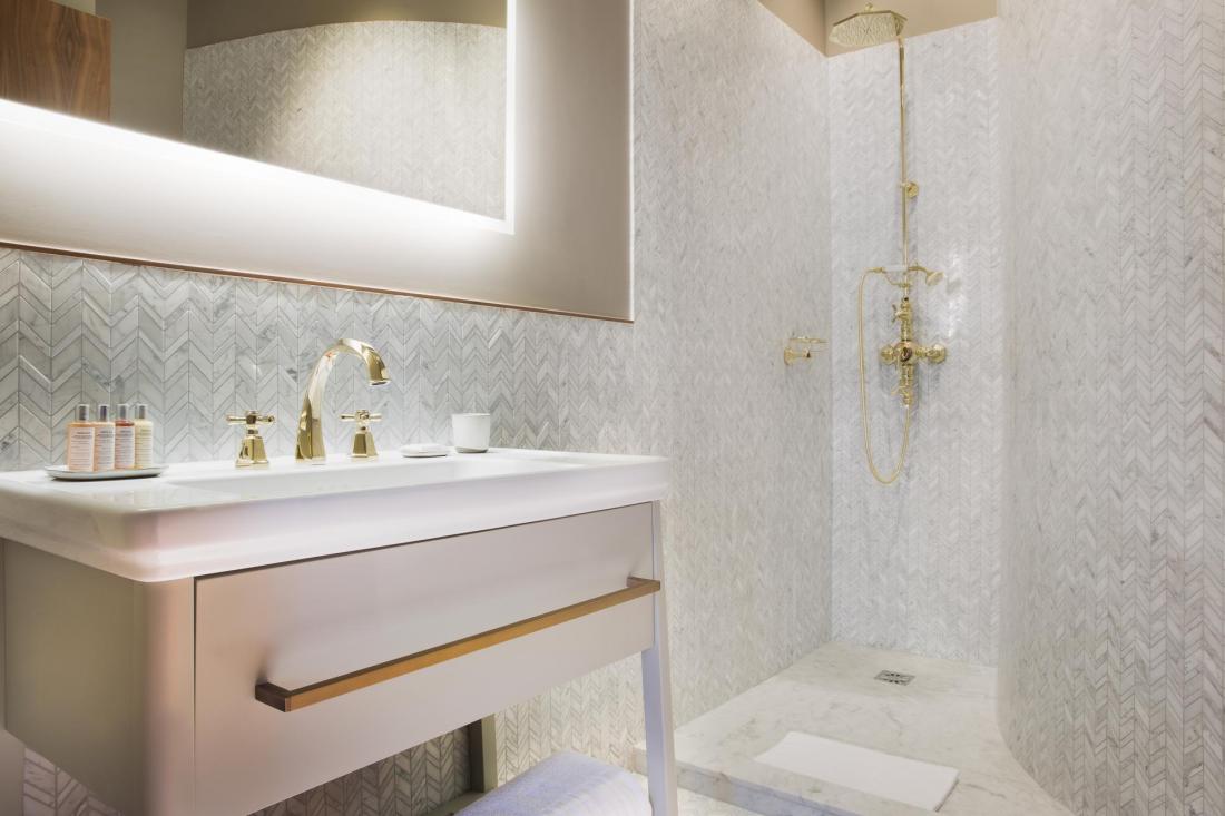 Du marbre de Carrare découpé en motif chevron recouvre toutes les salles de bains