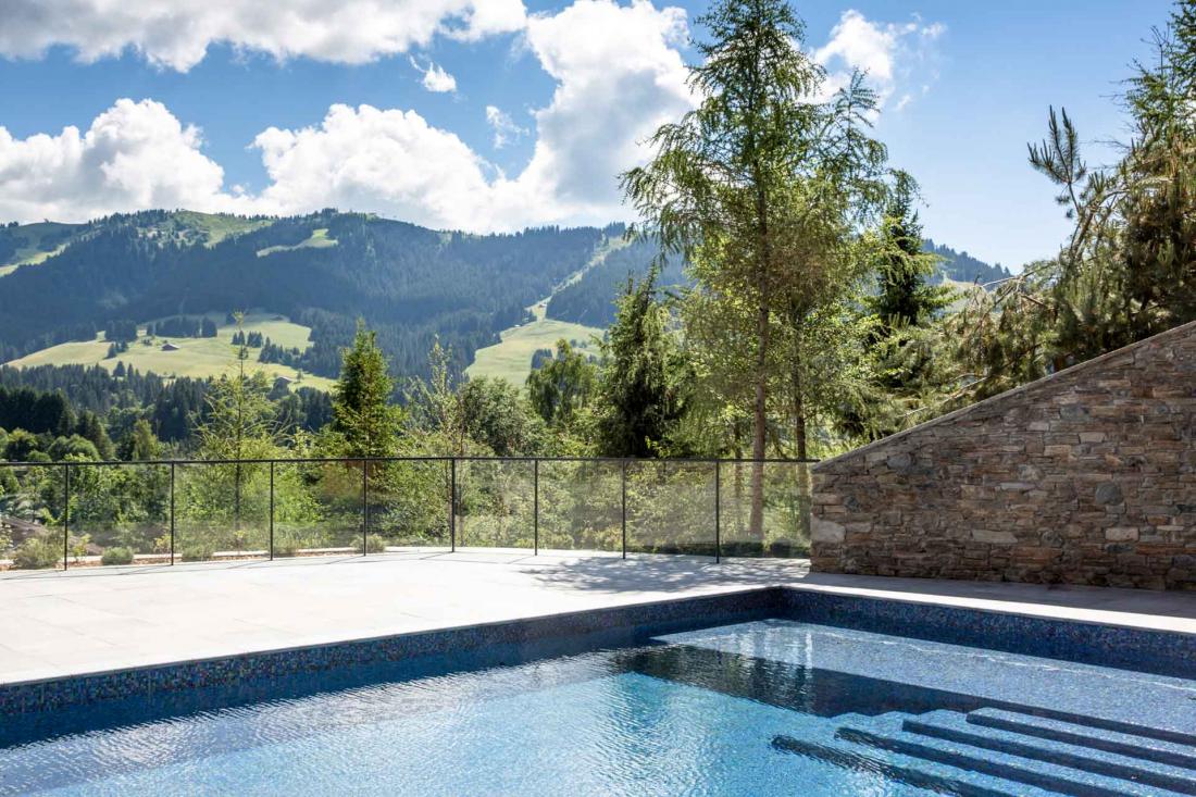 Le bassin de la piscine se prolonge vers l’extérieur, offrant de superbes vues sur les environs