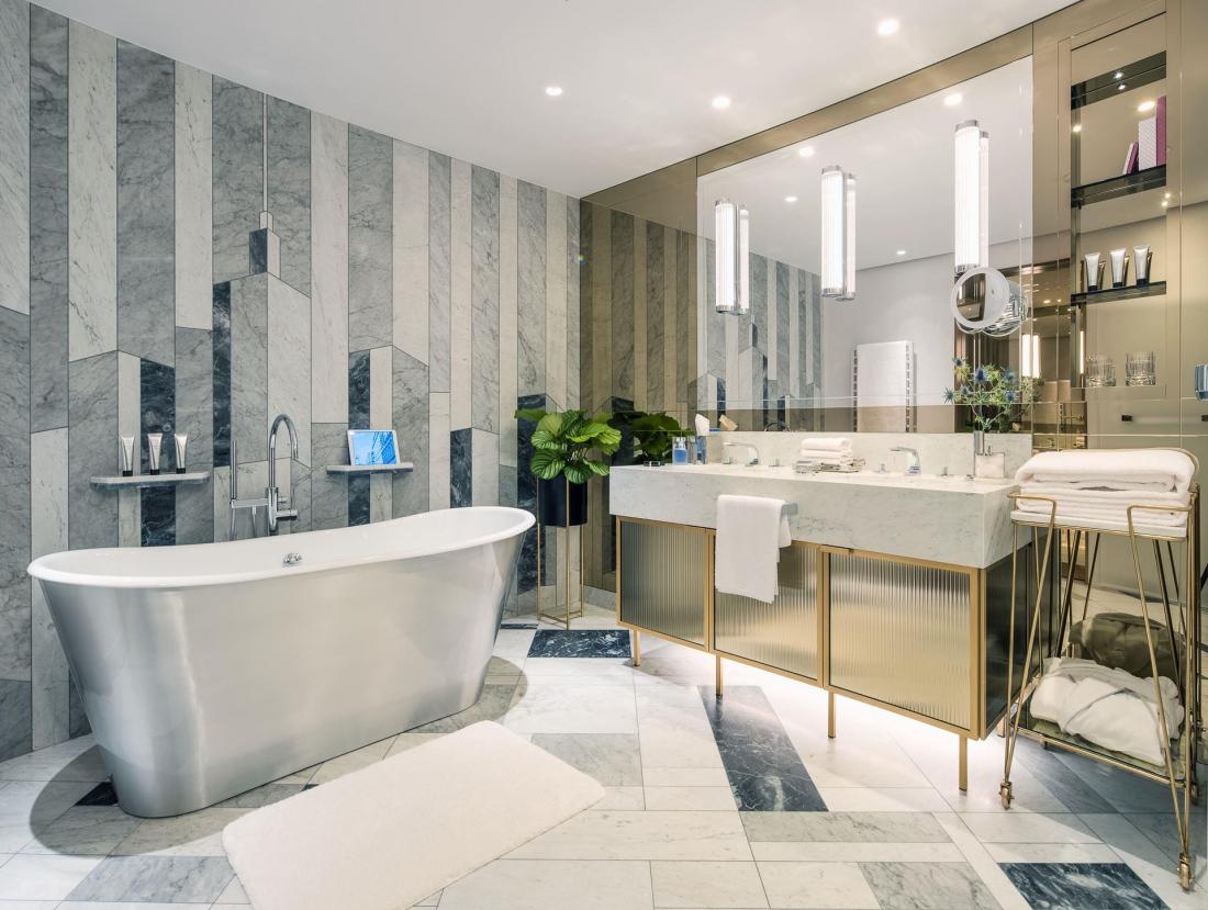 La salle de bain en marbre blanc, rehaussée de touches Art Déco, de la Grand Suite.