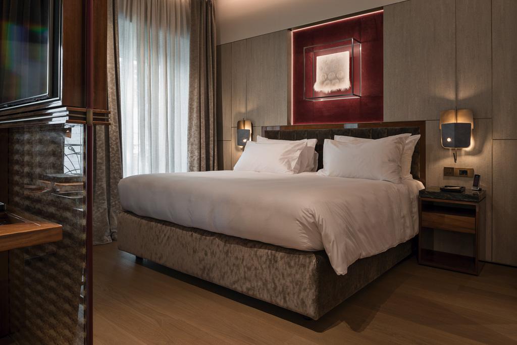 À l’intérieur des suites, les pièces à vivre sont séparées des chambres par des panneaux de verre aux cadres ajourés et des bureaux en bois