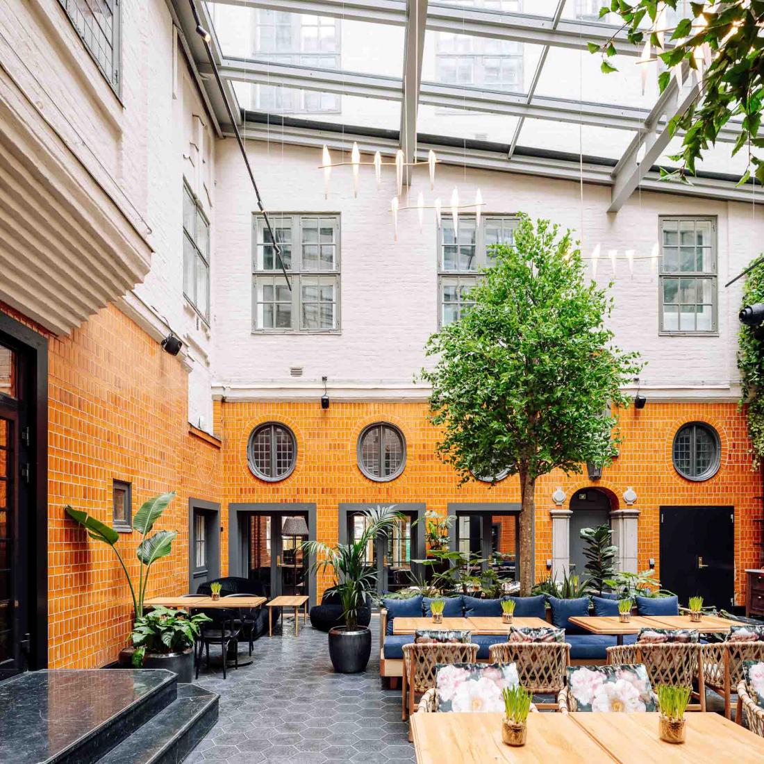 Le patio central, couvert d’un toit en verre, sert cafés et snacks pendant la journée, et un brunch les week-ends.