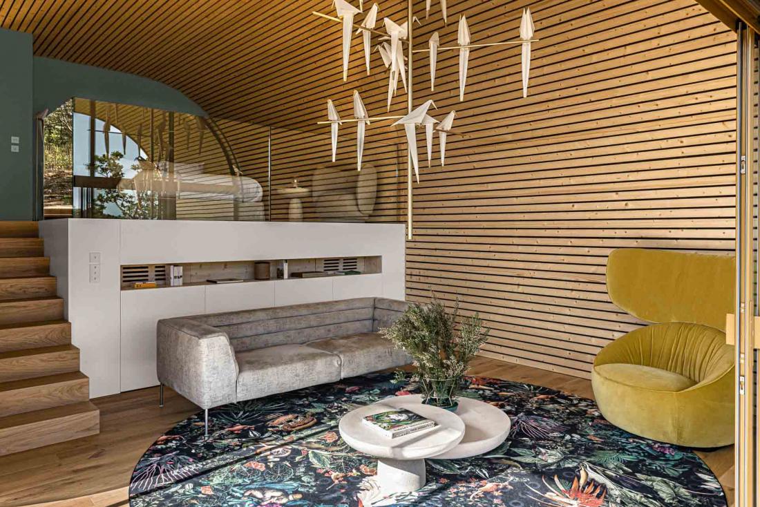 Espace salon et chambre en mezzanine dans des intérieurs en bois blond