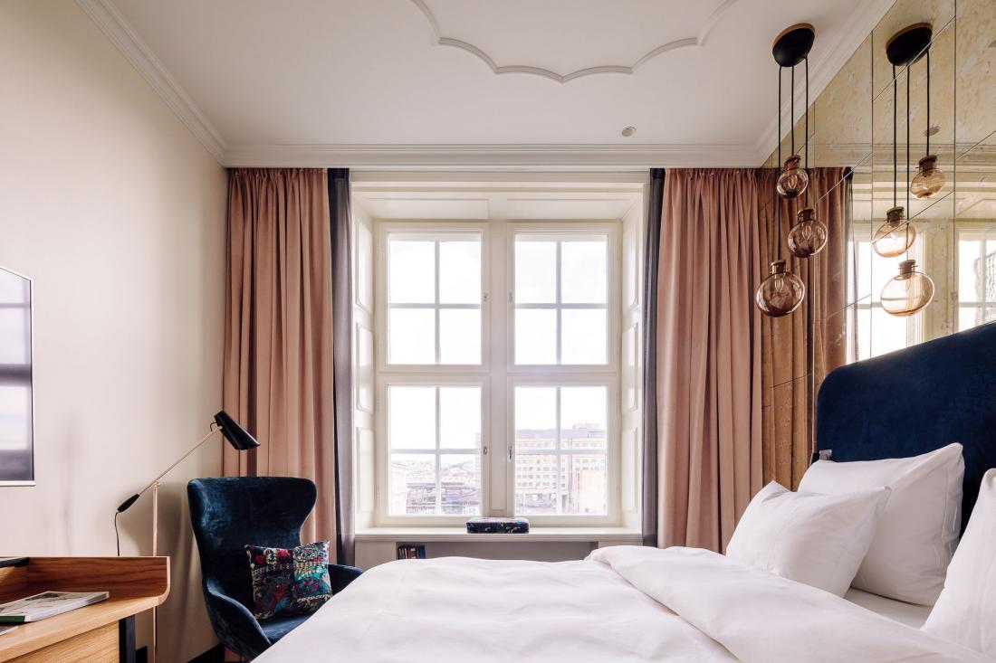 Les pièces sont vastes et aérées, avec une grande fenêtre et un miroir en verre fumé derrière le lit.