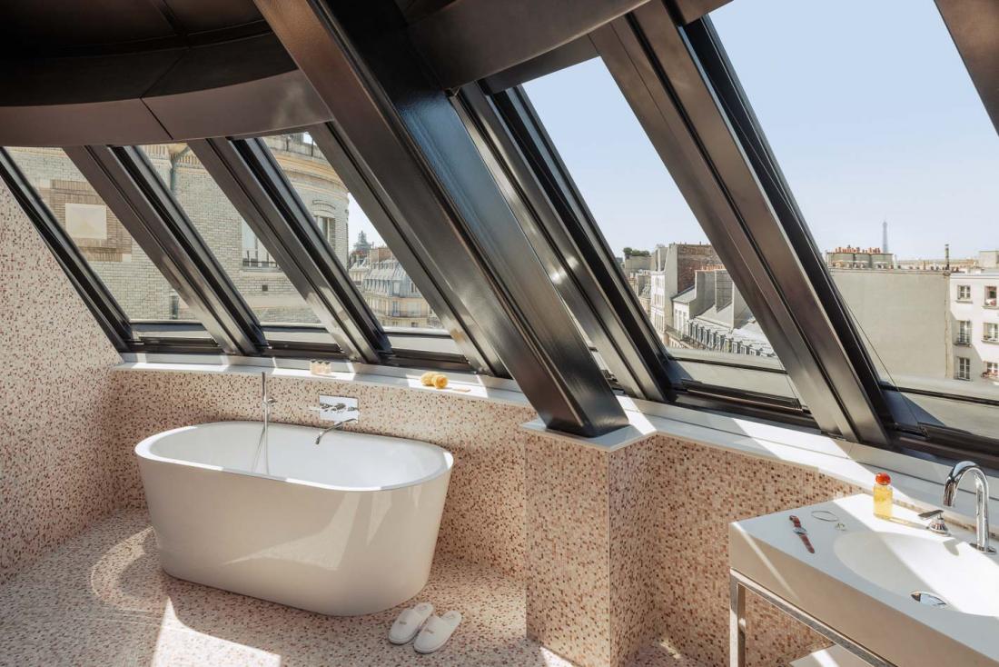 Dans un angle, la Suite Deluxe vue Tour Eiffel et sa baignoire d’où observer la pointe de la grande dame