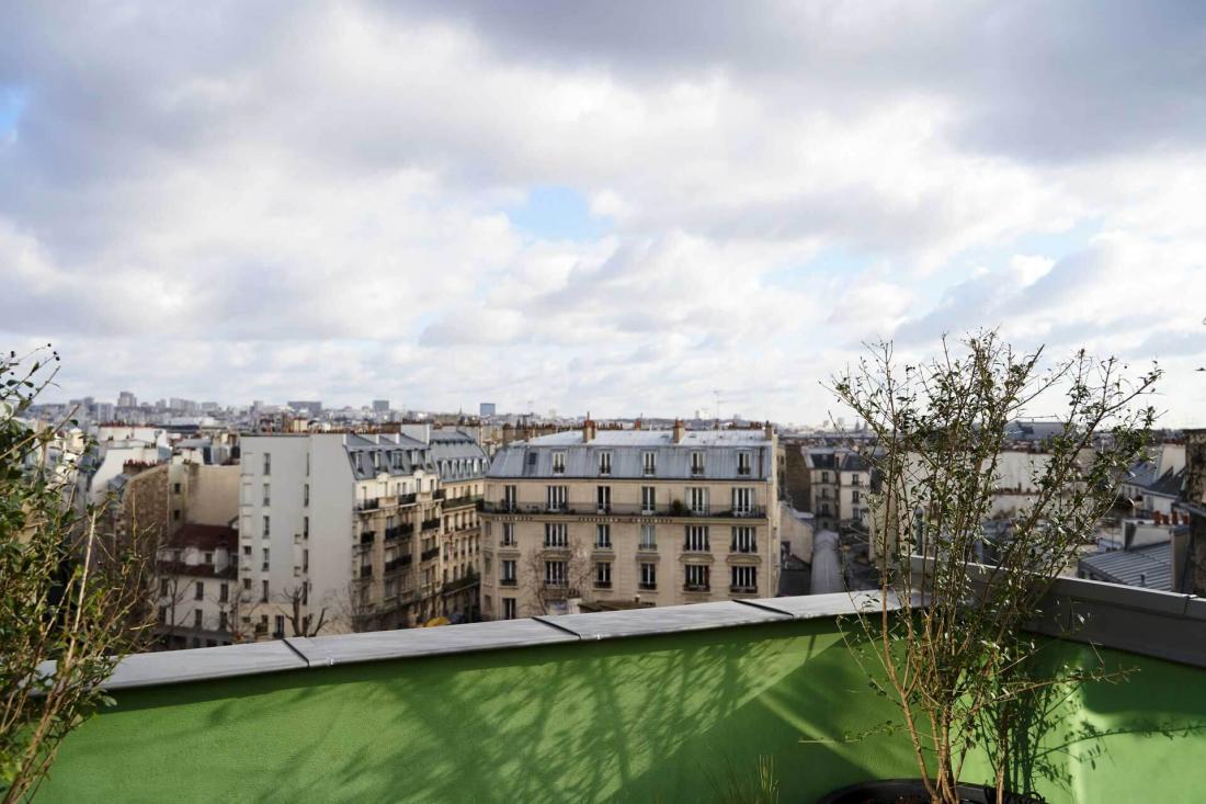 La vue couvre la Tour Eiffel d’un côté et la butte de Belleville de l’autre