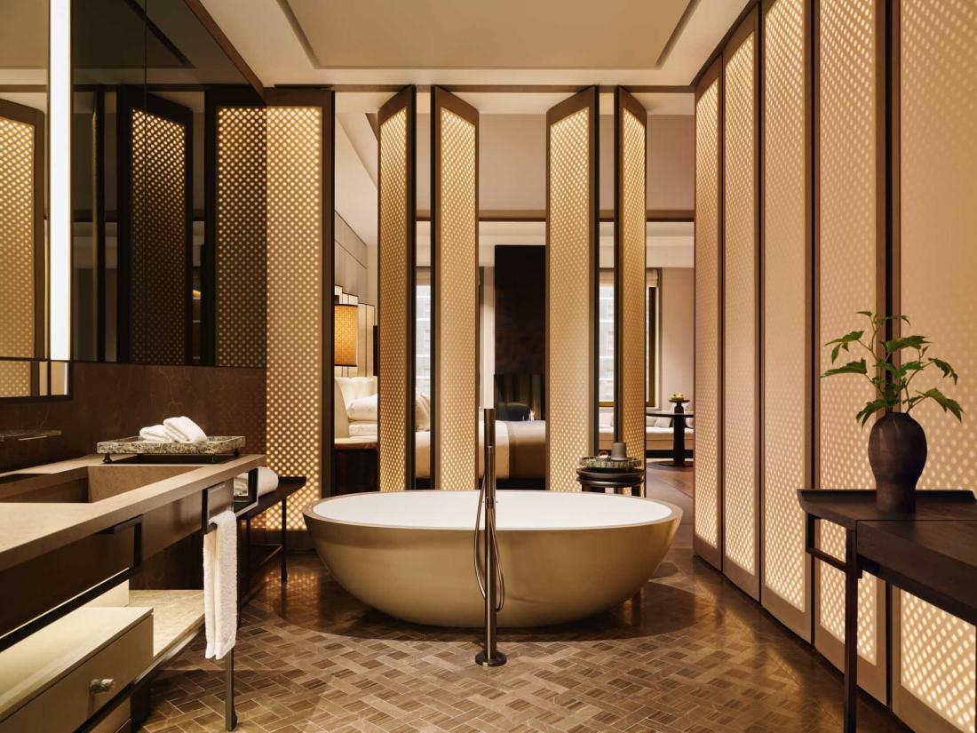 Ici, une immense salle de bain élégante séparée de la chambre par des panneaux coulissant