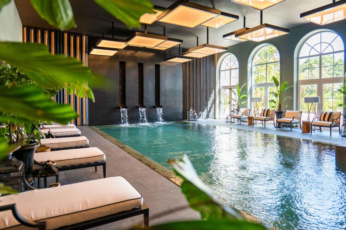 Une piscine intérieure baignée de lumière par de grandes baies comme une serre