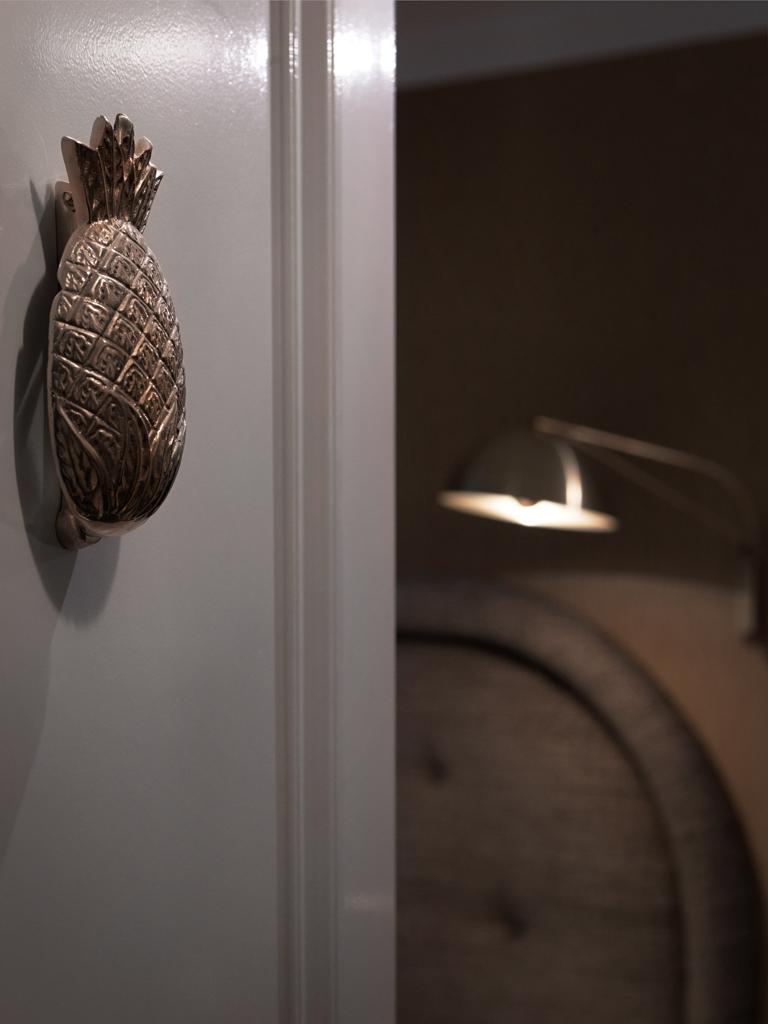 Un ananas doré, clin d’œil à l’univers des cocktails, souhaite la bienvenue aux voyageurs sur chaque porte