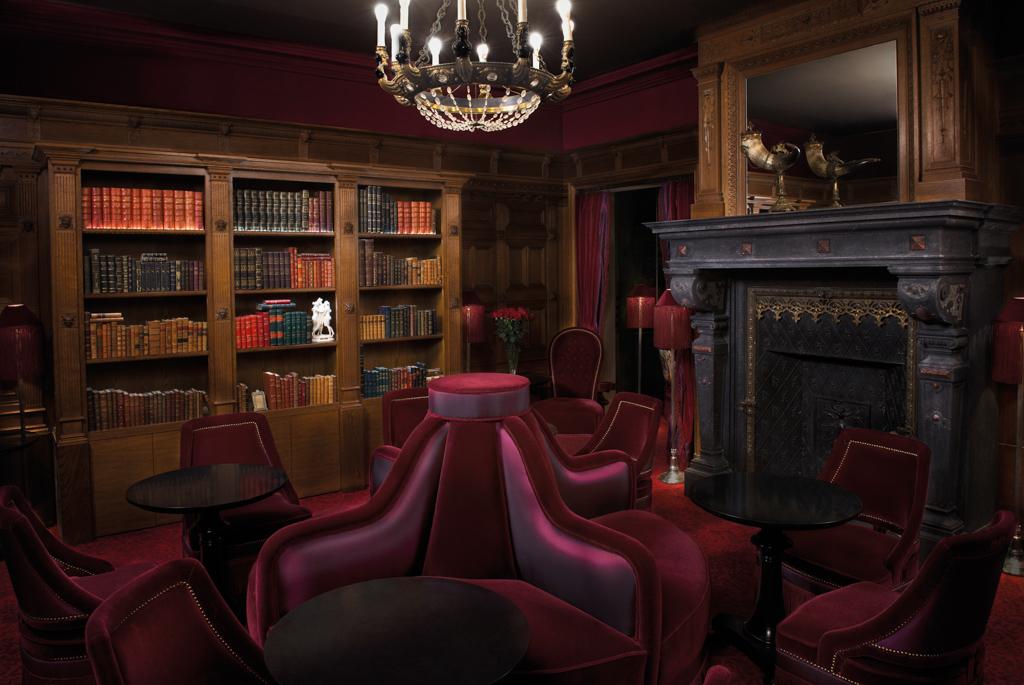 Malgré le léger aspect artificiel de l’image, on perçoit immédiatement le côté fastueux et intime du bar avec son imposante cheminée et sa grande bibliothèque.