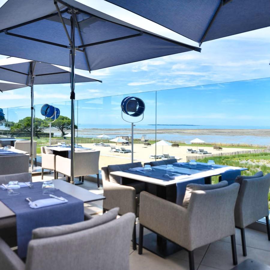 Des tables dressées captant la lumière changeante du littoral avec une vue constante sur l’océan. ©  La Grande Terrasse  