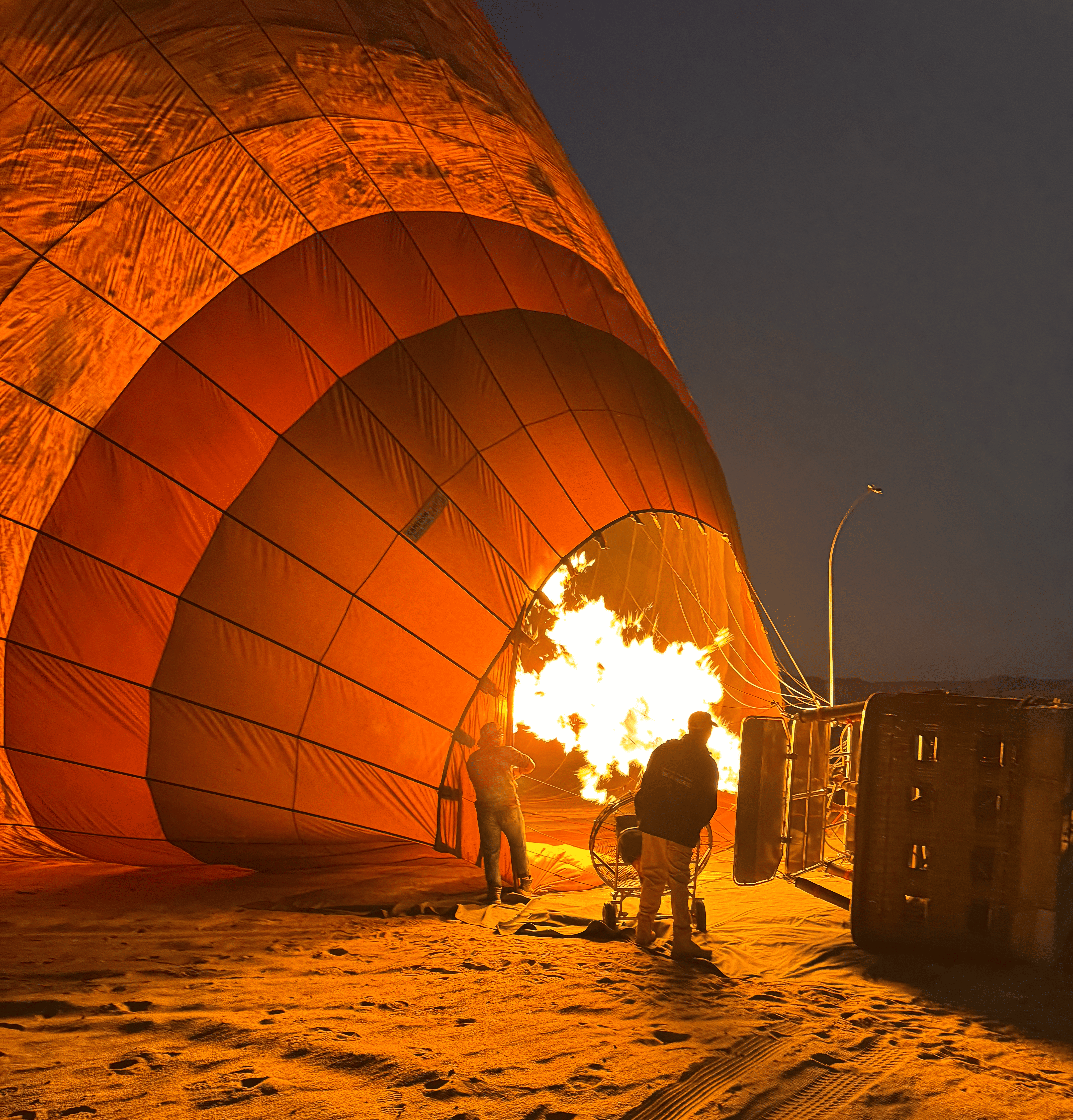 Lorsque les brûleurs s’embrasent, la toile de la montgolfière se gonfle lentement, se colore de rouge et d’orange, comme si le ciel prenait forme sous mes yeux © Hugues de Vaulx