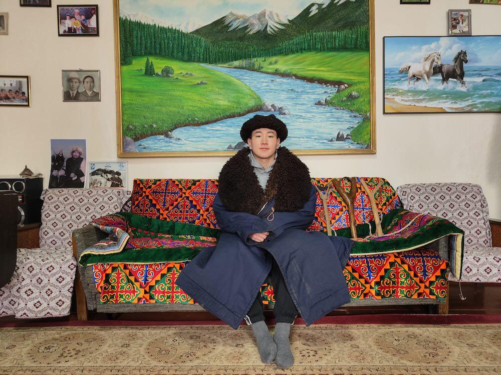 Portrait d’un jeune kirghize en tenue traditionnelle dans un intérieur typique, Kirghizistan © Emmanuel Laverand