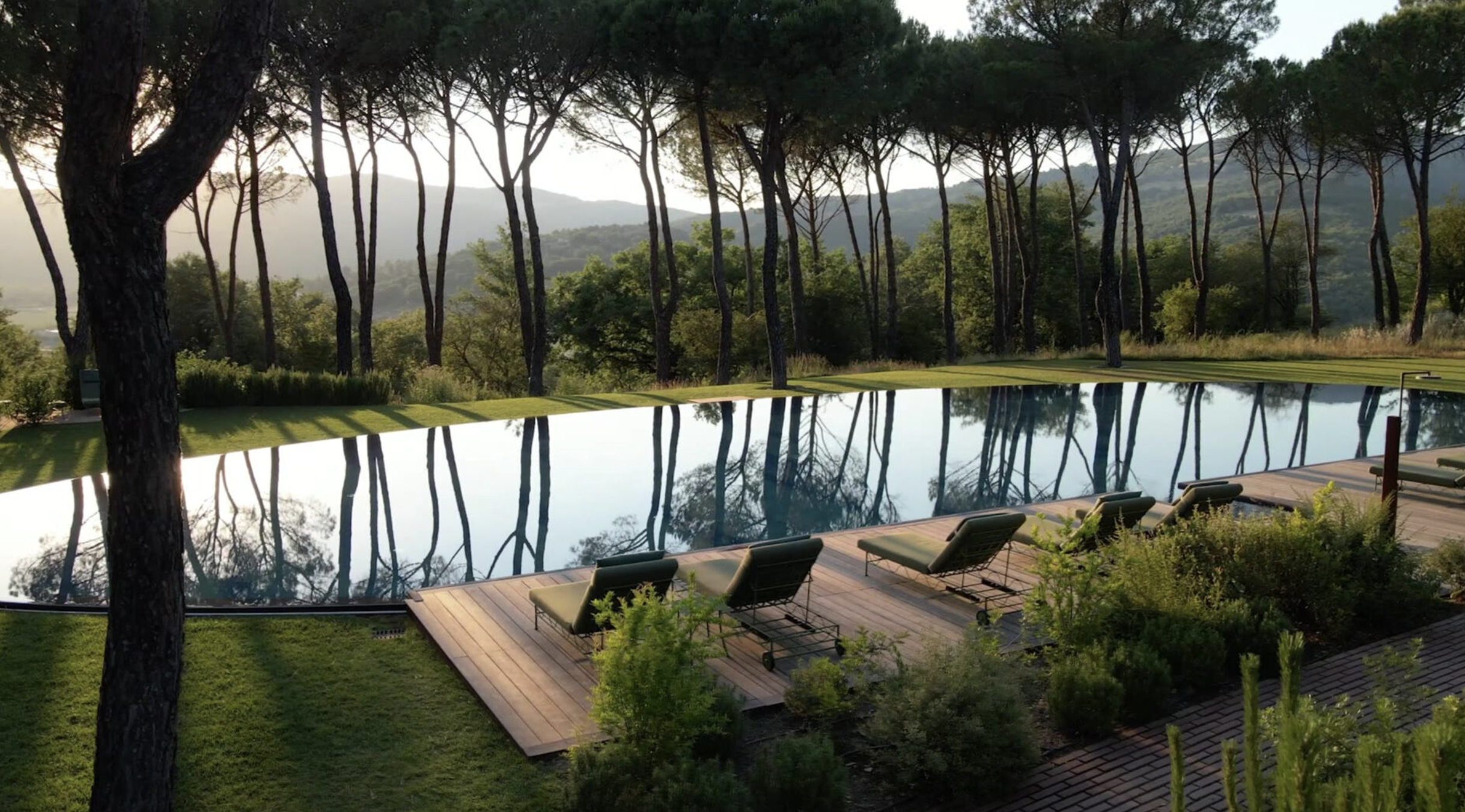 La piscine à travers les arbres en Toscane © Castello di Reschio