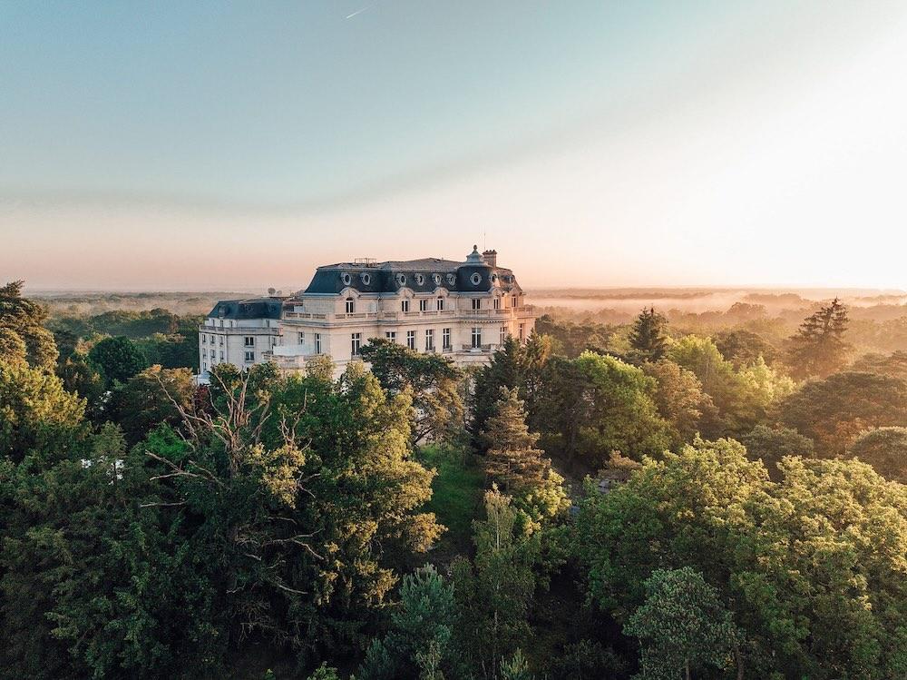 Au lever du jour, le château Mont Royal émerge de la brume au cœur de la forêt de Chantilly © InterContinental Chantilly Château Mont Royal