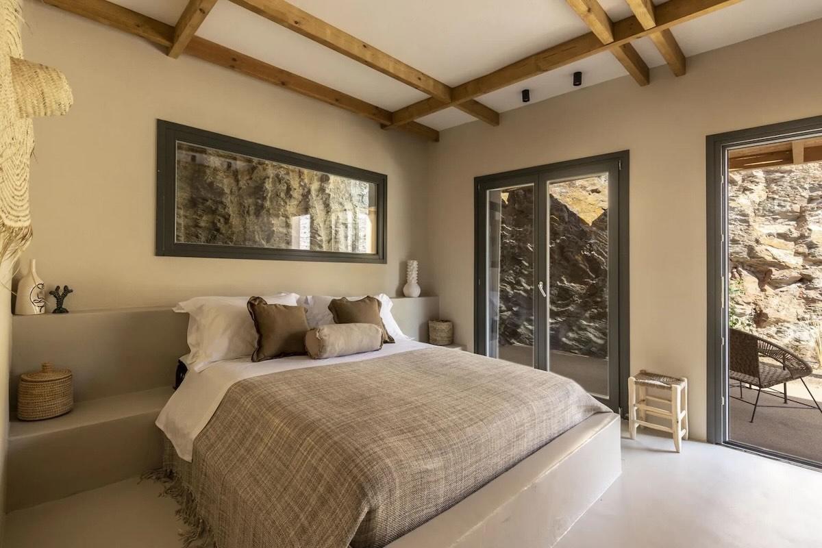 Poutres apparentes, lin et tons sable : la roche de Kéa s’invite jusque dans les chambres de la villa Koundos, villa de luxe des Cyclades. © Le Collectionist