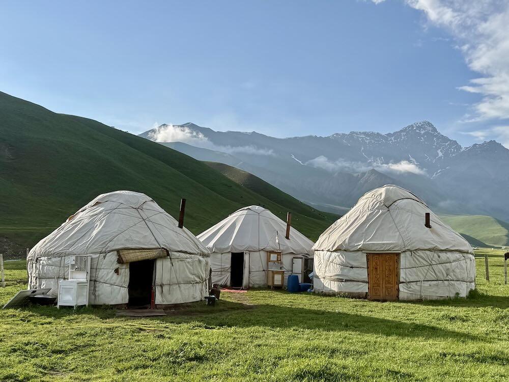 En fin de journée, les yourtes du campement face aux sommets pris dans les nuages © DR