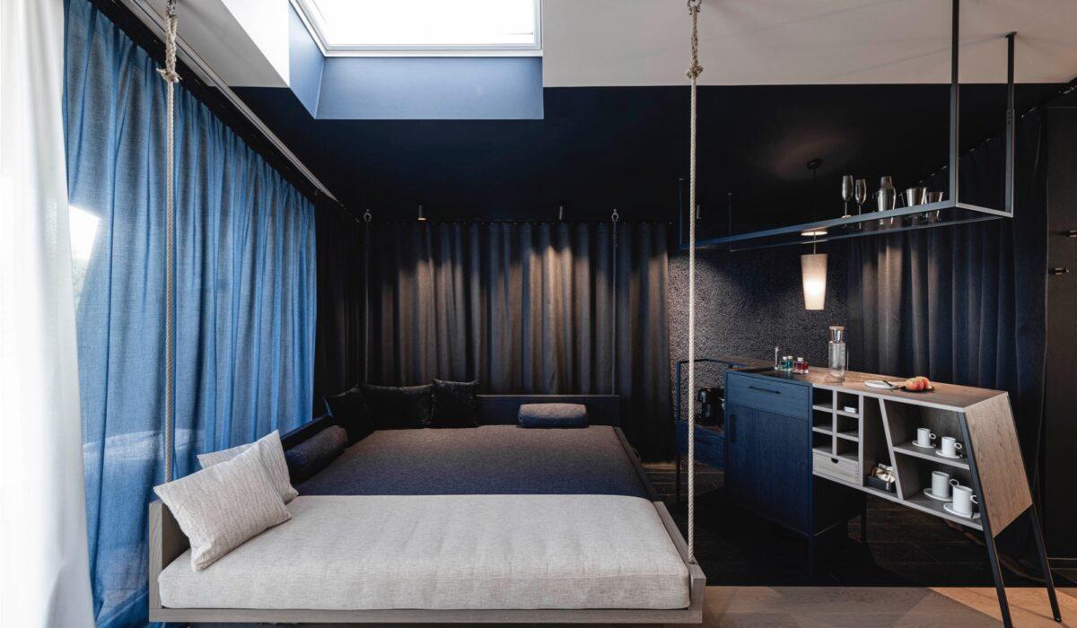 Le lit de jour, apparemment suspendu au plafond, est, comme le reste de la chambre divisé en un côté bleu et un côté blanc. © ÆON