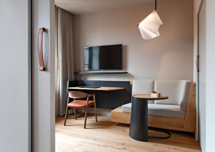 Coin salon dans une suite. L’abat-jour du luminaire rappelle la coiffe des religieuses qui tenaient la clinique autrefois installée dans le bâtiment. © Les Haras