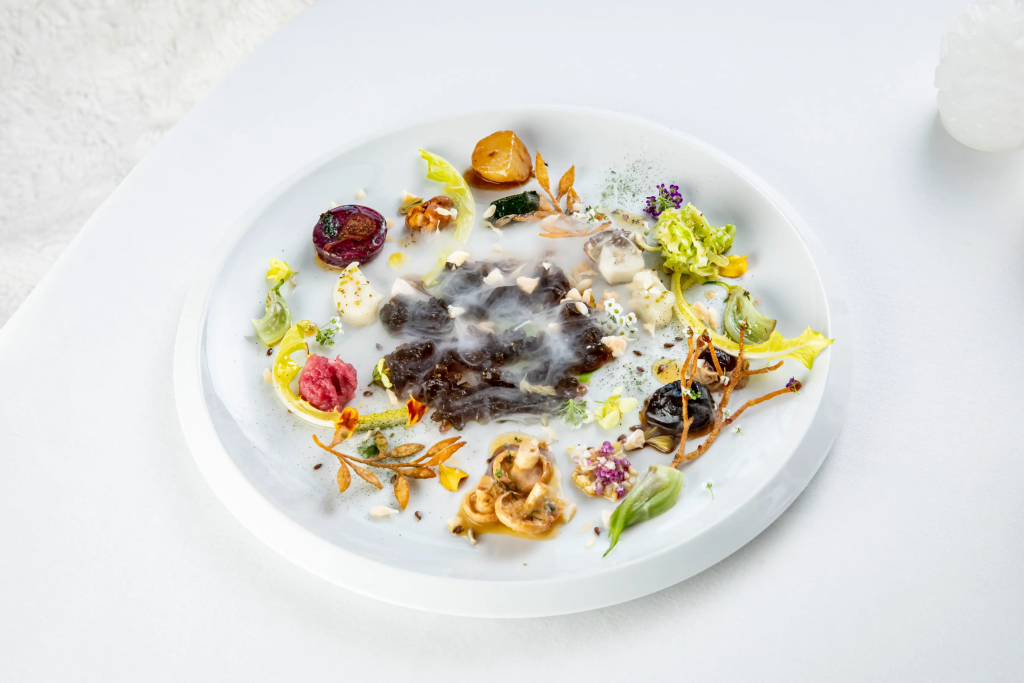 Glisser d’une neige parfaite à un déjeuner en terrasse face aux sommets, puis conclure la journée autour d’une table étoilée : c'est la magie de Courchevel. Portée par une concentration rare de restaurants de très haut niveau, la station cultive aussi des adresses chics et chaleureuses, ouvertes sur les saveurs du monde.