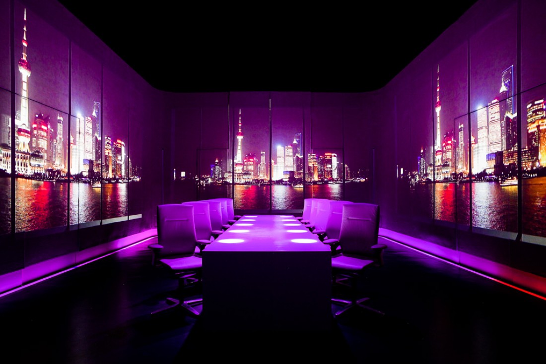 Au centre de la salle à manger d'Ultraviolet by Paul, une table pour dix convives. Sur les murs, une projection d'une vue de Shanghai © Scott Wright