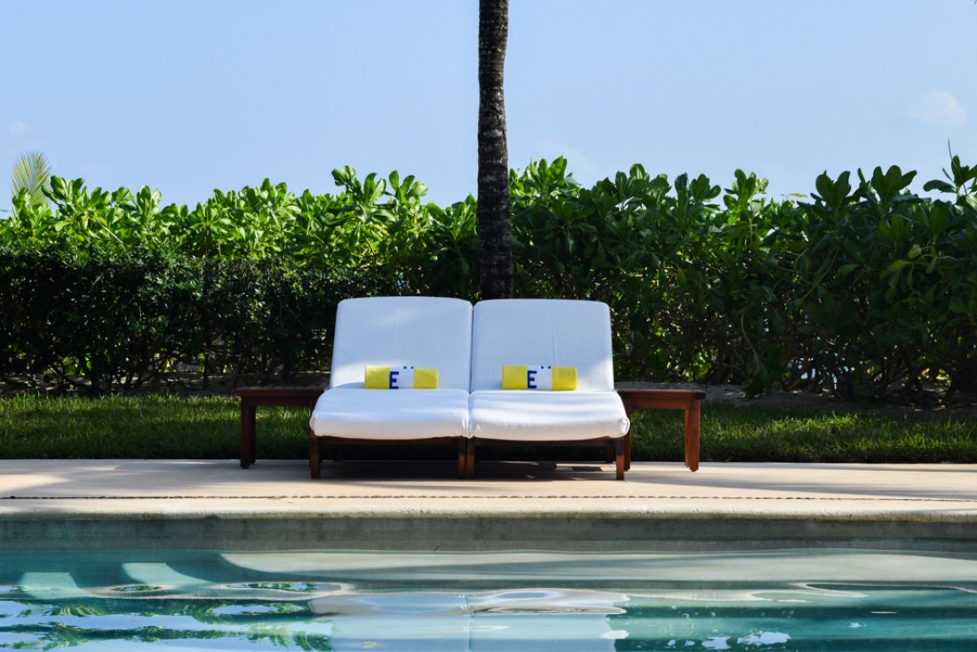 Deux transats isolés, une piscine, le soleil, un palmier : le paradis selon Esencia © Yonder.fr