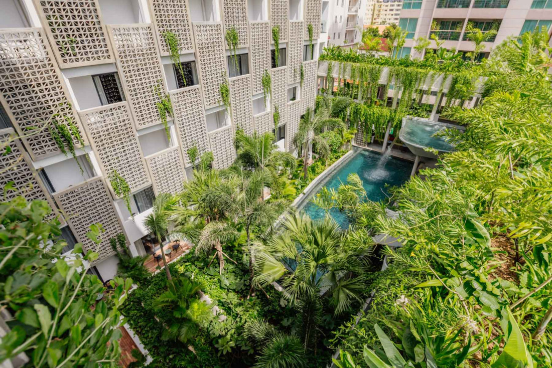 Béton et végétation luxuriante se mêlent autour de la piscine du Baitong Hotel © Baitong Hotel & Resort Phnom Penh