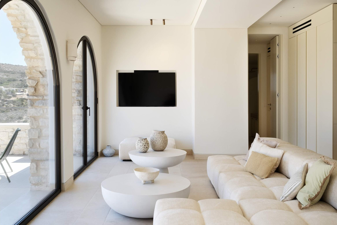 Baies cintrées, tons crème et poteries brutes : le salon d’Arches Soros joue la carte de la douceur. Une villa de luxe des Cyclades tout en lumière. © Oliaros Villa Rentals