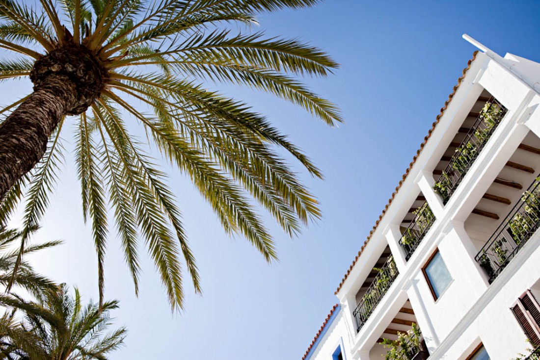 Façade blanche et palmiers, bienvenue aux 105 Suites © Yann Deret