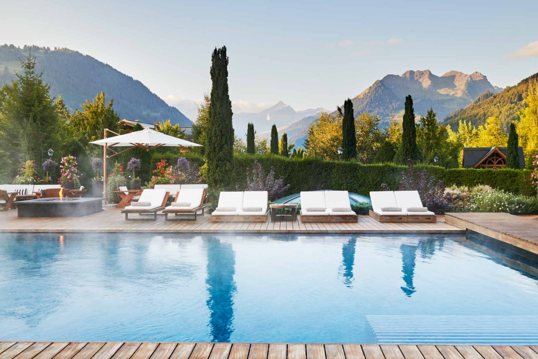 L'Alpina Gstaad et sa piscine entourée des montagnes © The Alpina Gstaad