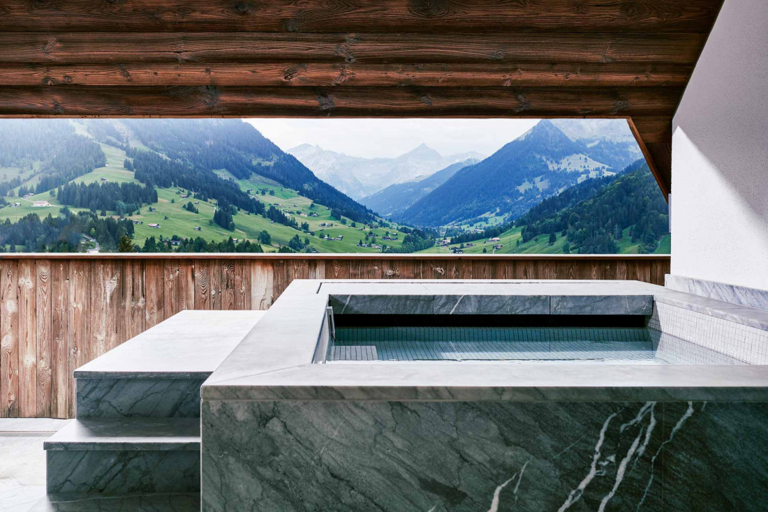 La Panorama Suite de l'hôtel Alpina à Gstaad et son propre jacuzzi avec vue sur les Alpes © Alpina