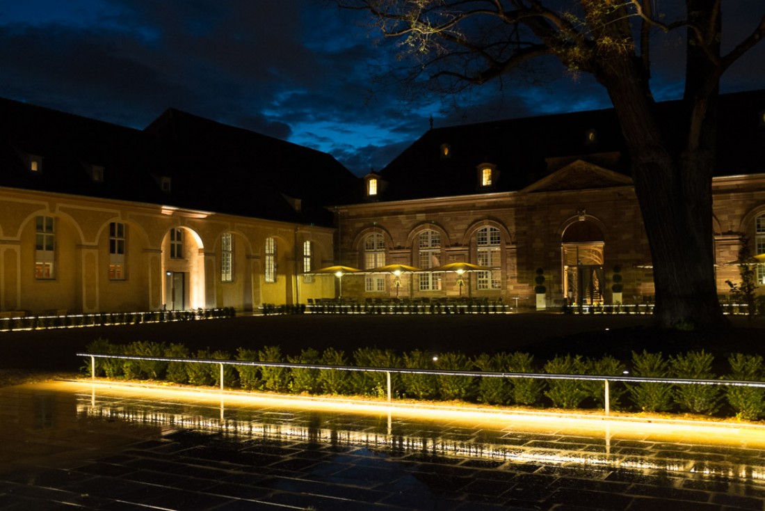 La grande cour vue de nuit, où s’exerçaient autrefois les chevaux des haras. La brasserie occupe le bâtiment de droite.