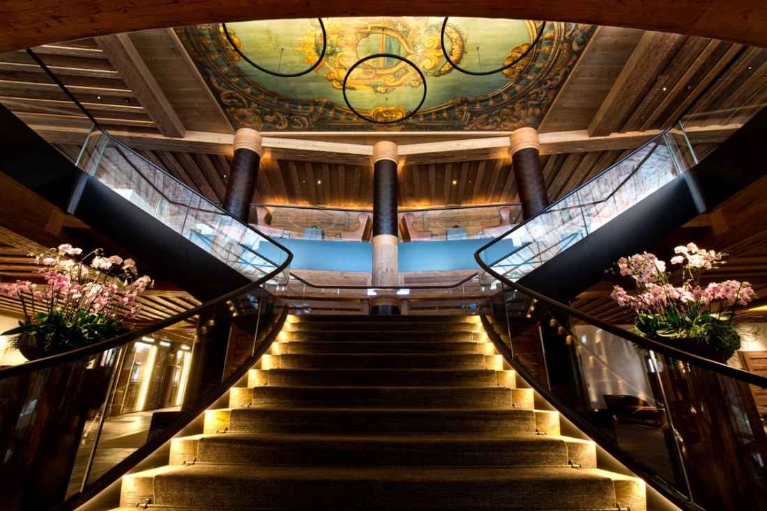 Un fastueux escalier à double révolution accueille les voyageurs arrivant à l’hôtel | © The Alpina Gstaad