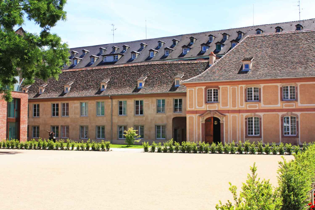 Façade du bâtiment dans la cour des Haras. A l'arrière plan, la double rangée de fenêtres du toit du bâtiment de l'aile ajoutée en 2021. © Les Haras