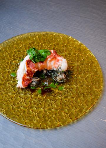 À l'issue de la cuisson, un véritable plat est dressé autour du homard avec escargots et persillade © YONDER.fr