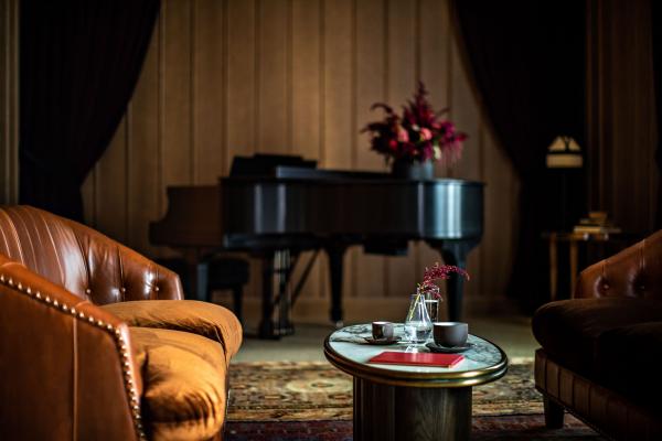 Un piano Steinway, fermé dans un coin, attend la soirée pour des performances intimistes. 