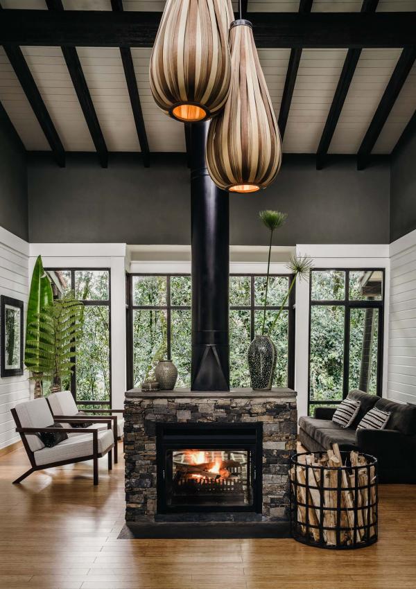 Le salon où brule un feu réconfortant et la terrasse privée en bois complète la chambre pour former un nid au milieu de la nature.  
