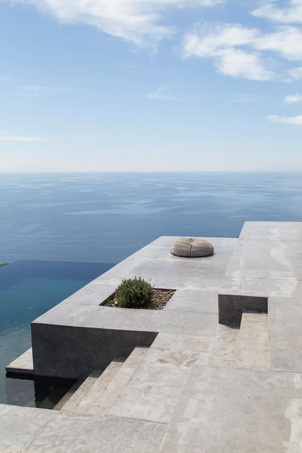 Suspendues au-dessus de la mer, les terrasses minérales de cette villa de luxe des Cyclades n’ont que l’horizon pour décor. © Le Collectionist