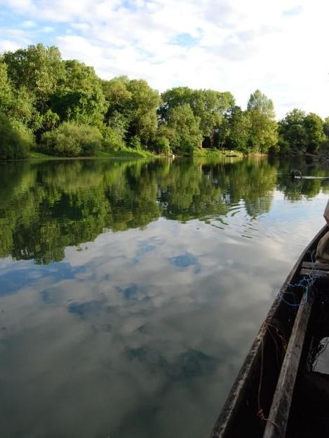 Emmanuel Favin manœuvre sa barque le long de la Seine entre une faune et une flore foisonnantes © CDT Aube