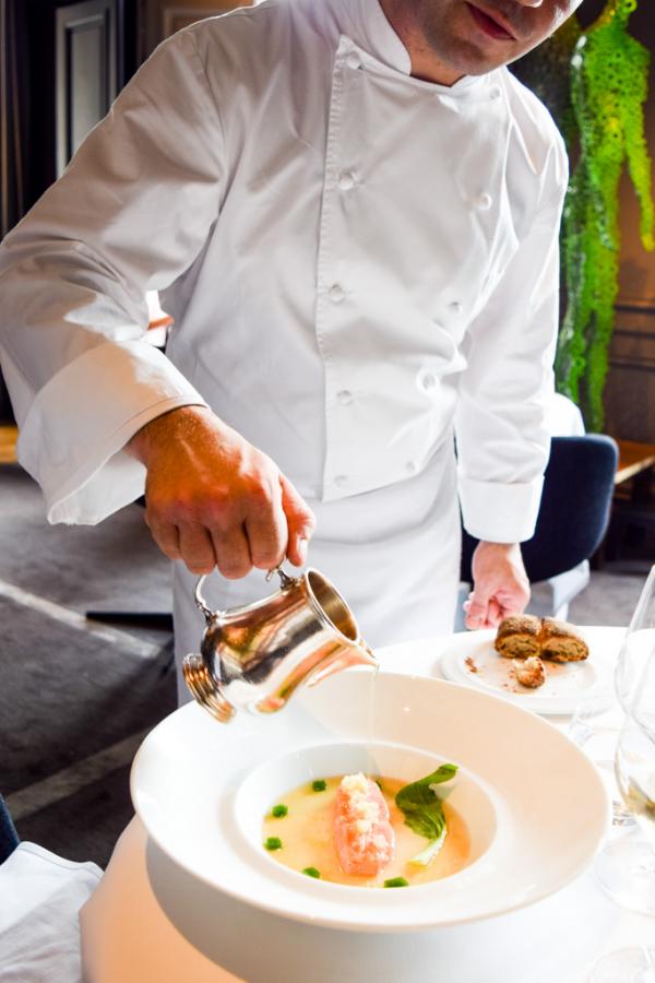 Un consommé brûlant est versé sur le saumon "figé" : l'assiette s'apprête à être servie © Yonder.fr