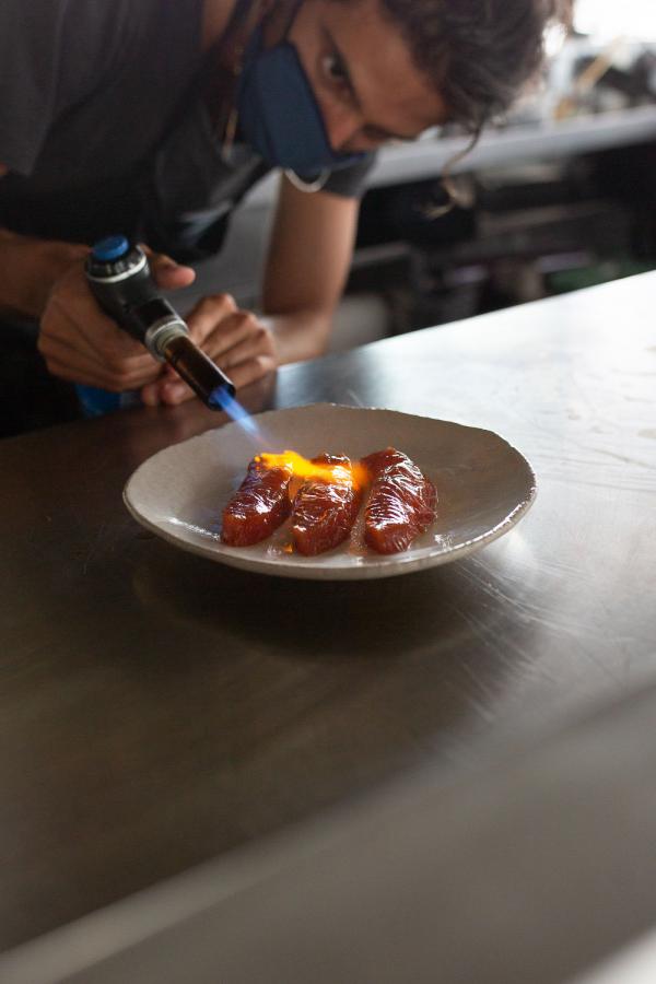 Tortuga | Préparation du saumon séché, mariné teryaki et enfin flambé au chalumeau © The Social Food