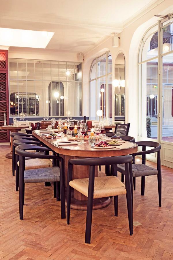 Une grande table d'hôtes, dans l'espace intérieur du restaurant © Karel Balas