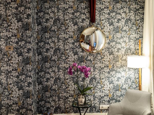 Le papier peint et le miroir de la chambre rappellent les choix faits par Barnaba Fornasetti, fils de Piero, dans sa propre maison. © DB / Yonder