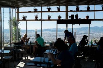 Une paroi en verre pour vous abriter du vent tout en profitant de la vue depuis le Lycabette.