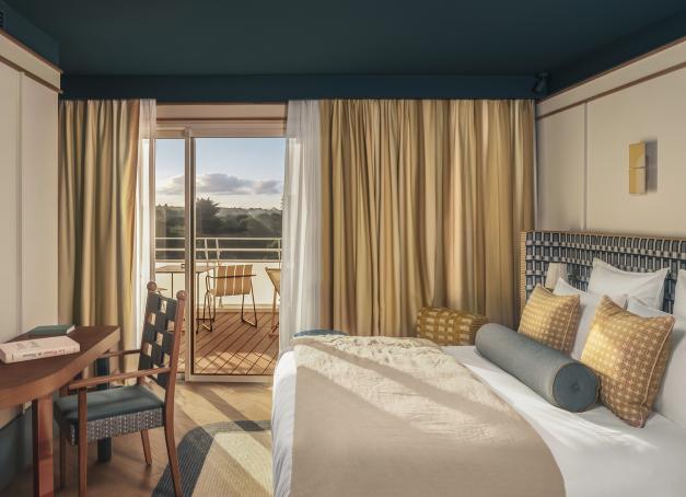 Ouvert en juillet 2026, Les Cimes Bleues est la première adresse de La French Collection, la marque hôtelière du Groupe Giboire. Entre pins maritimes et grand large, ce boutique-hôtel 4 étoiles signé Dorothée Delaye réinterprète les codes des sports élégants baulois : golf, équitation, tennis, dans un décor sport-chic. 101 chambres avec vue, deux restaurants et un spa Alaena : la station balnéaire tient enfin son adresse lifestyle.